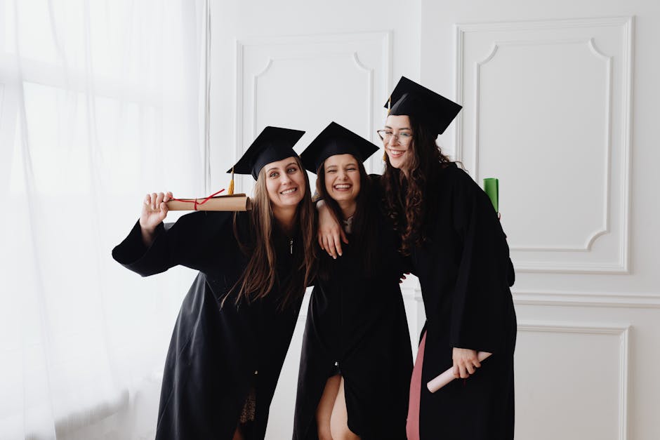 Smiling graduates in caps and gowns celebrating outdoors on a sunny summer day
